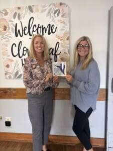 Two women holding a certificate for Dementia Friendly Business between them